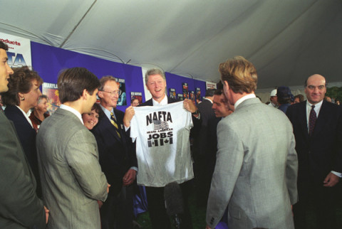 President William J. Clinton participating in a NAFTA products event on the South Lawn of the White House. President Clinton holds up a t-shirt that says "NAFTA Means American Jobs."